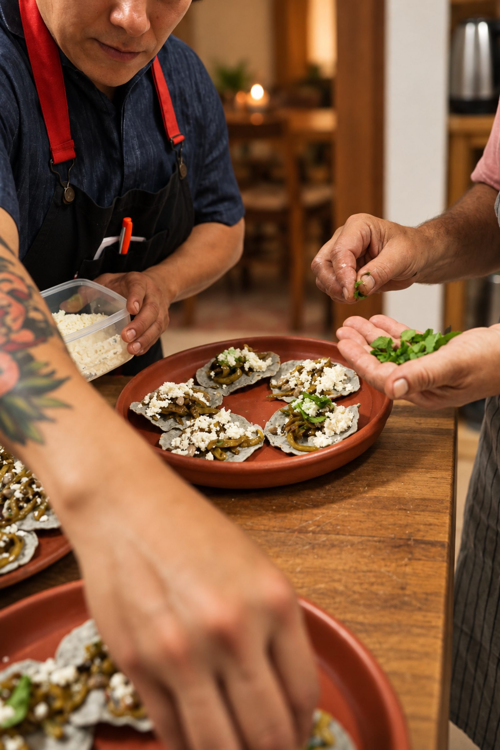 Hands plating tostadas in a cooking class